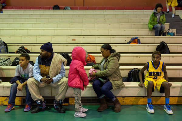 Amani with his family before a game.  Damon Winter / The New York Times